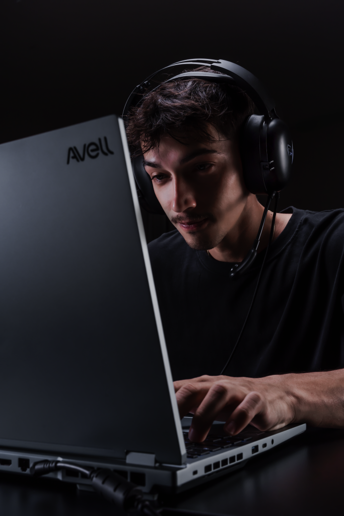 Homem utilizando notebook Avell com headset profissional, representando o uso de tecnologias avançadas em 2025, como inteligência artificial e conectividade de alta velocidade